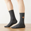 Chaussettes hautes pour homme. Motif brodé Bretzel. Fond gris chiné foncé. Idéales pour les gourmands.