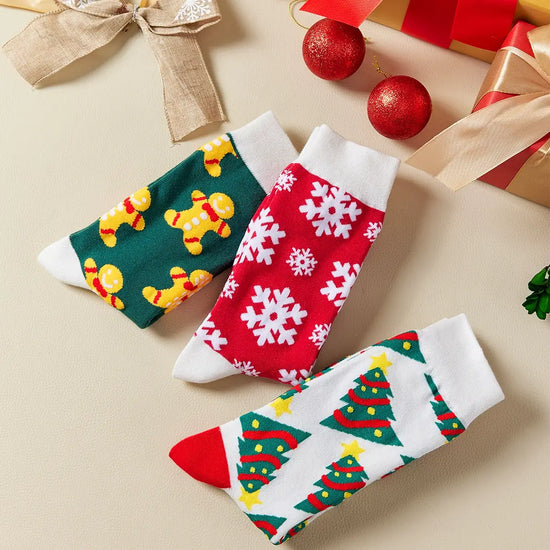 Chaussettes hautes de Noël avec motifs festifs : sapin, flocon, biscuit. Douces, chaudes et stylées pour un hiver cosy et un look joyeux à Noël.