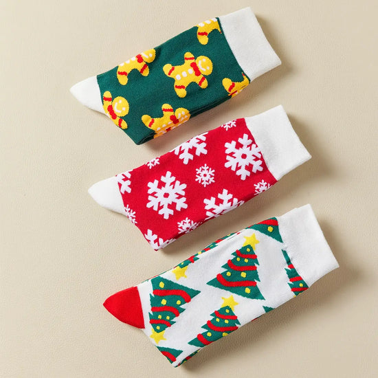 Chaussettes hautes de Noël avec motifs festifs : sapin, flocon, biscuit. Douces, chaudes et stylées pour un hiver cosy et un look joyeux à Noël.