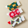 Chaussettes hautes de Noël avec motifs festifs : sapin, flocon, biscuit. Douces, chaudes et stylées pour un hiver cosy et un look joyeux à Noël.