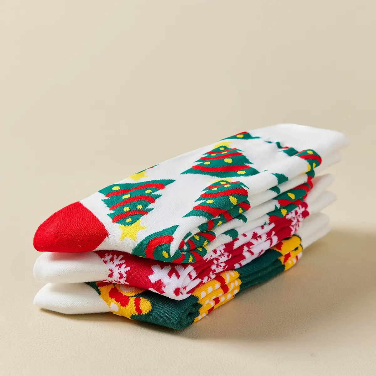 Chaussettes hautes de Noël avec motifs festifs : sapin, flocon, biscuit. Douces, chaudes et stylées pour un hiver cosy et un look joyeux à Noël.