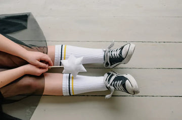 jambe de petite fille portant des chaussettes hautes et une baguette magique