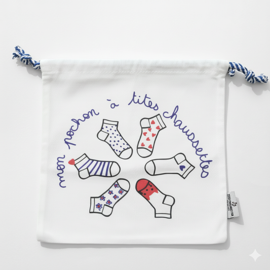 Pochon coton pour ranges ses Tites Chaussettes. Fond blanc, imprimé chaussettes à motifs bleu/rouge. Fermeture par lien coulissant blanc/bleu. 