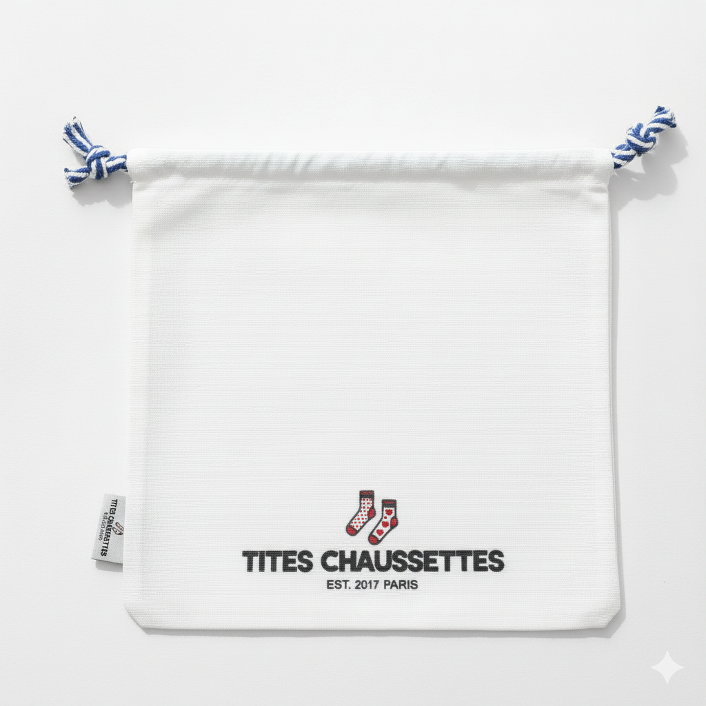 Pochon coton pour ranges ses Tites Chaussettes. Fond blanc, imprimé chaussettes à motifs bleu/rouge. Fermeture par lien coulissant blanc/bleu. 
