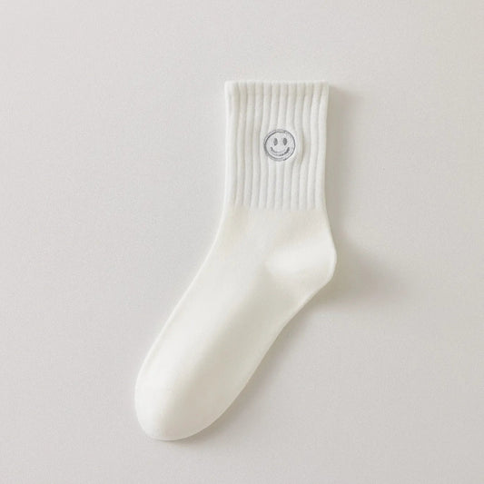 Chaussettes blanches montantes avec smiley, confortables et stylées, idéales avec des baskets. Coton épais, look tendance et maintien optimal.