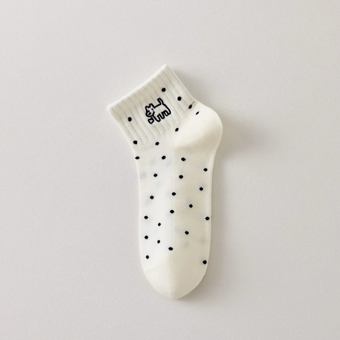 Chaussette femme noir et blanc vendue à l’unité, brodée d’un motif chien graphique. Taille 35-41. Confortable, douce et originale pour un look casual chic.