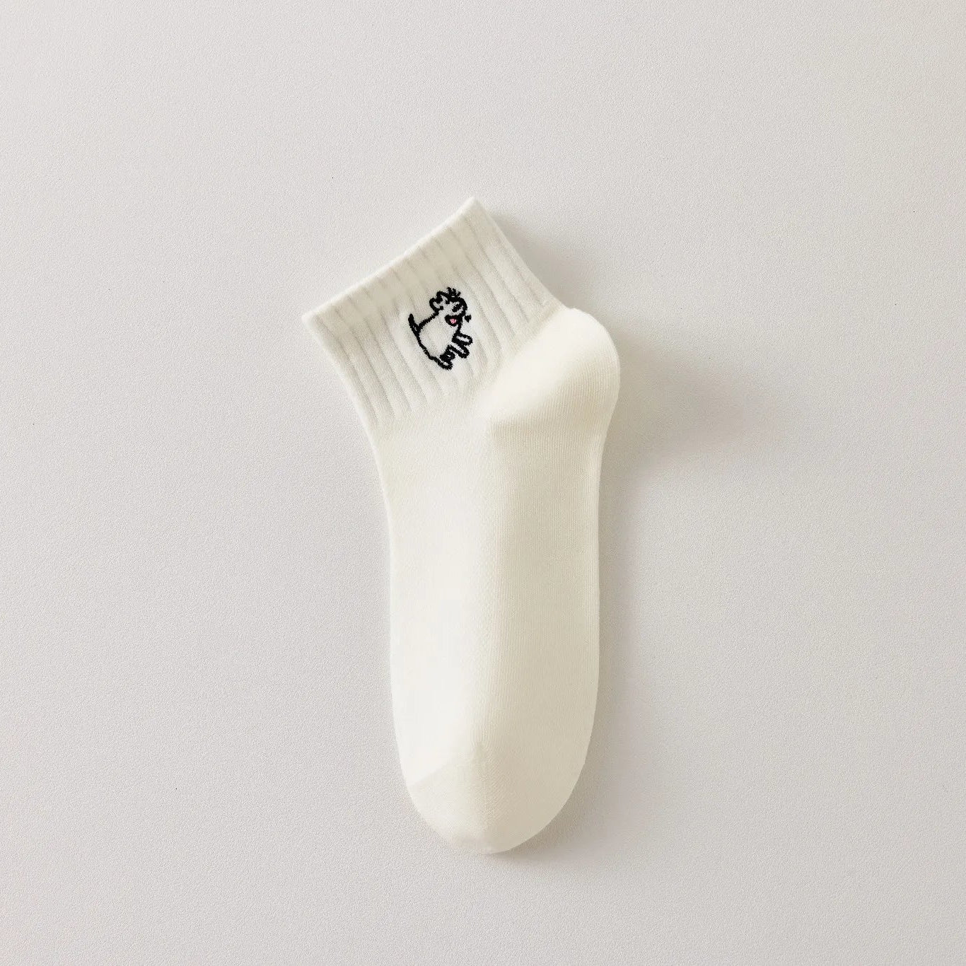 Chaussette femme noir et blanc vendue à l’unité, brodée d’un motif chien graphique. Taille 35-41. Confortable, douce et originale pour un look casual chic.