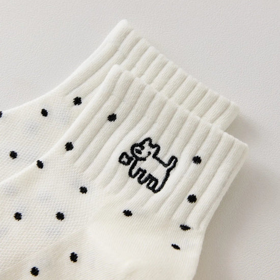 Chaussette femme noir et blanc vendue à l’unité, brodée d’un motif chien graphique. Taille 35-41. Confortable, douce et originale pour un look casual chic.