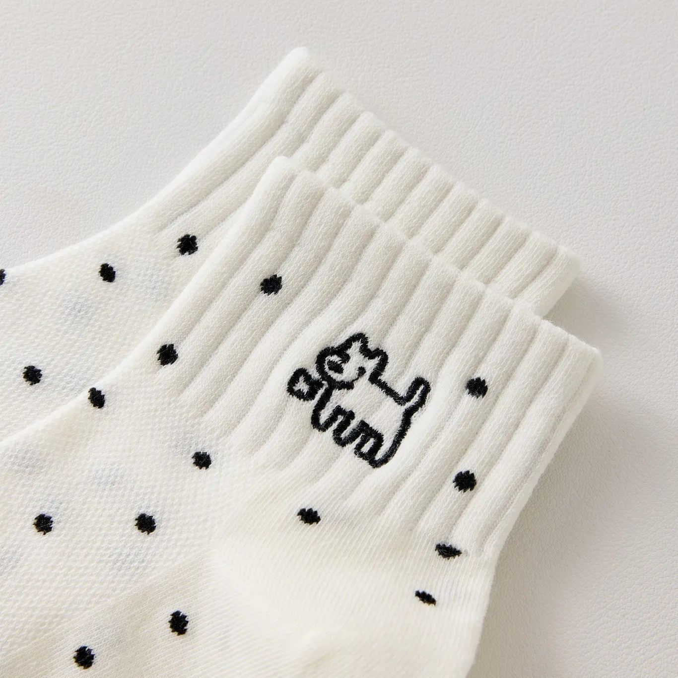 Chaussette femme noir et blanc vendue à l’unité, brodée d’un motif chien graphique. Taille 35-41. Confortable, douce et originale pour un look casual chic.