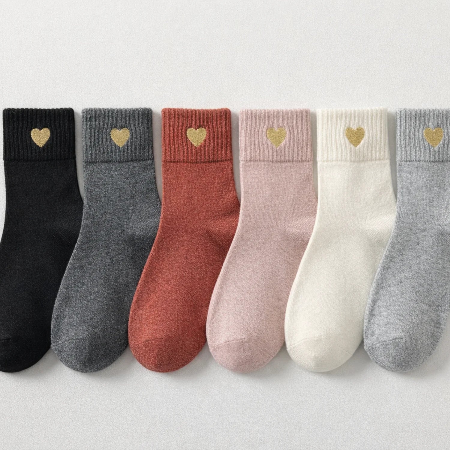 Chaussette haute chaude avec cœur doré brodé.