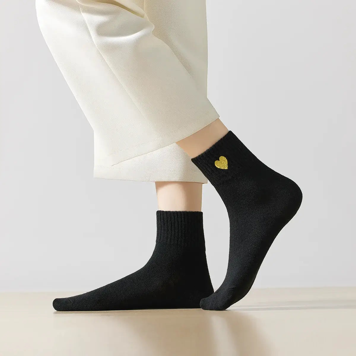 Chaussette haute chaude avec cœur doré brodé.