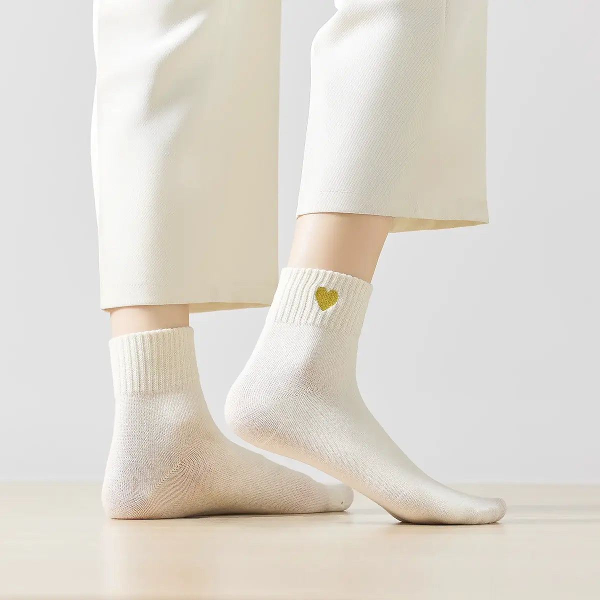 Chaussette haute chaude avec cœur doré brodé.