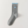 Chaussettes femme montantes avec coeur brodé sur le côté. Haut de tige volanté. Coeur et volant contrastés. 