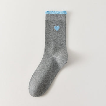 Chaussettes femme montantes avec coeur brodé sur le côté. Haut de tige volanté. Coeur et volant contrastés. 