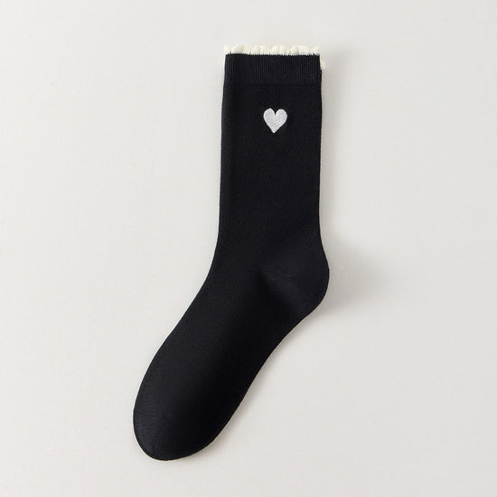 Chaussettes femme montantes avec coeur brodé sur le côté. Haut de tige volanté. Coeur et volant contrastés. 
