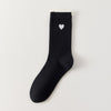 Chaussettes femme montantes avec coeur brodé sur le côté. Haut de tige volanté. Coeur et volant contrastés. 