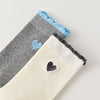 Chaussettes femme montantes avec coeur brodé sur le côté. Haut de tige volanté. Coeur et volant contrastés. 