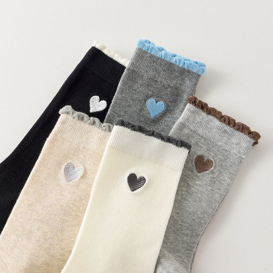 Chaussettes femme montantes avec coeur brodé sur le côté. Haut de tige volanté. Coeur et volant contrastés. 