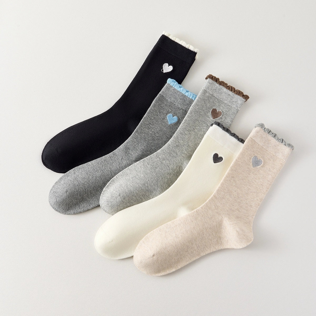 Chaussettes femme montantes avec coeur brodé sur le côté. Haut de tige volanté. Coeur et volant contrastés. 