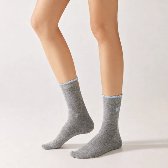Chaussettes femme montantes avec coeur brodé sur le côté. Haut de tige volanté. Coeur et volant contrastés. 