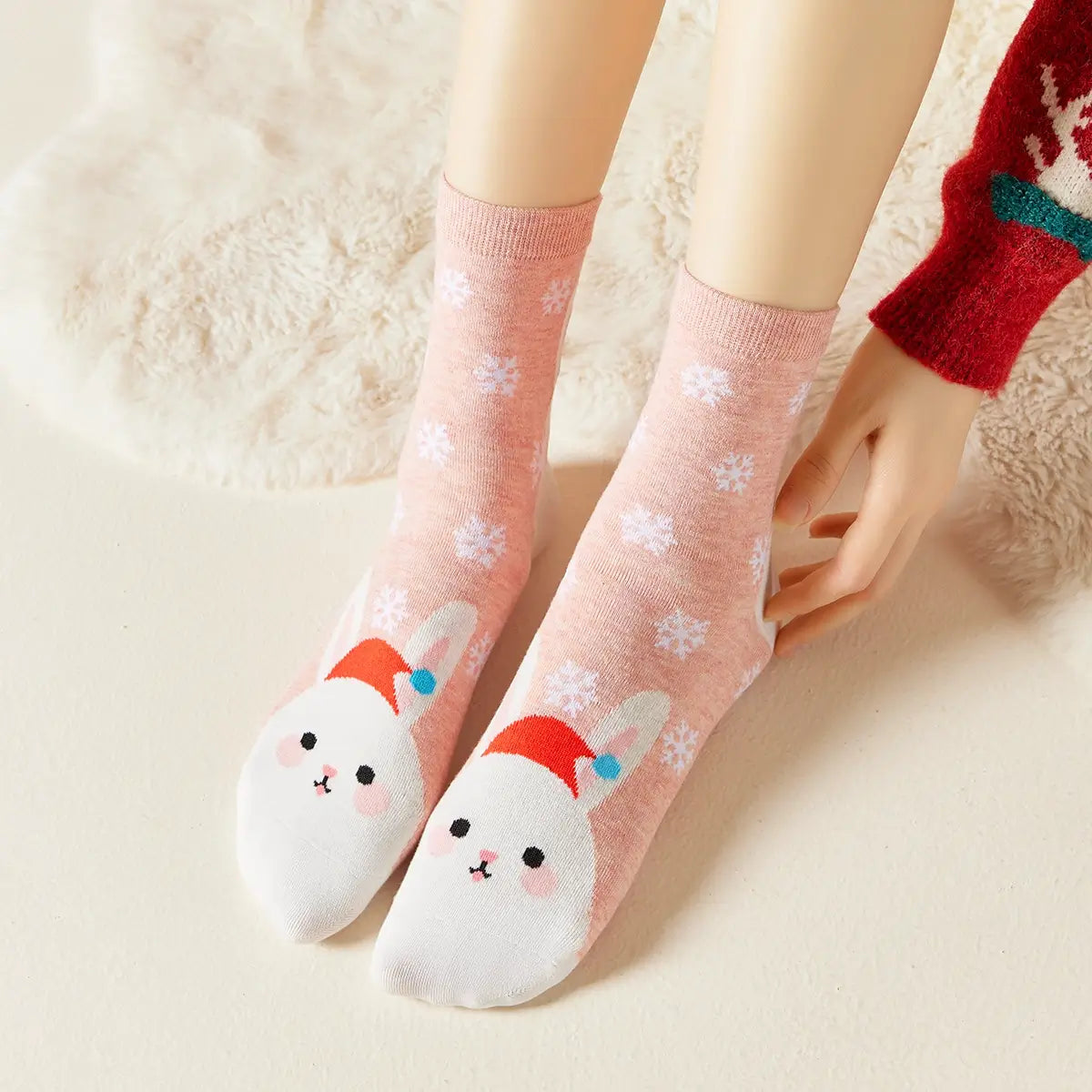 Chaussettes roses de noël motif flocons et tête de lapin portant un bonnet de noël 