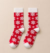 Chaussettes hautes de Noël avec motifs festifs : flocon de neige et bonhomme pain d'épice. Douces, chaudes et stylées pour un hiver cosy et un look joyeux à Noël.