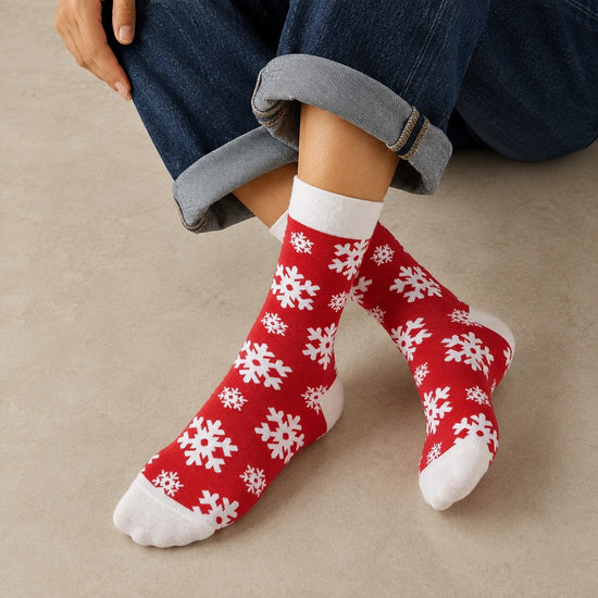 Chaussettes hautes de Noël avec motifs festifs : flocon de neige et bonhomme pain d'épice. Douces, chaudes et stylées pour un hiver cosy et un look joyeux à Noël.