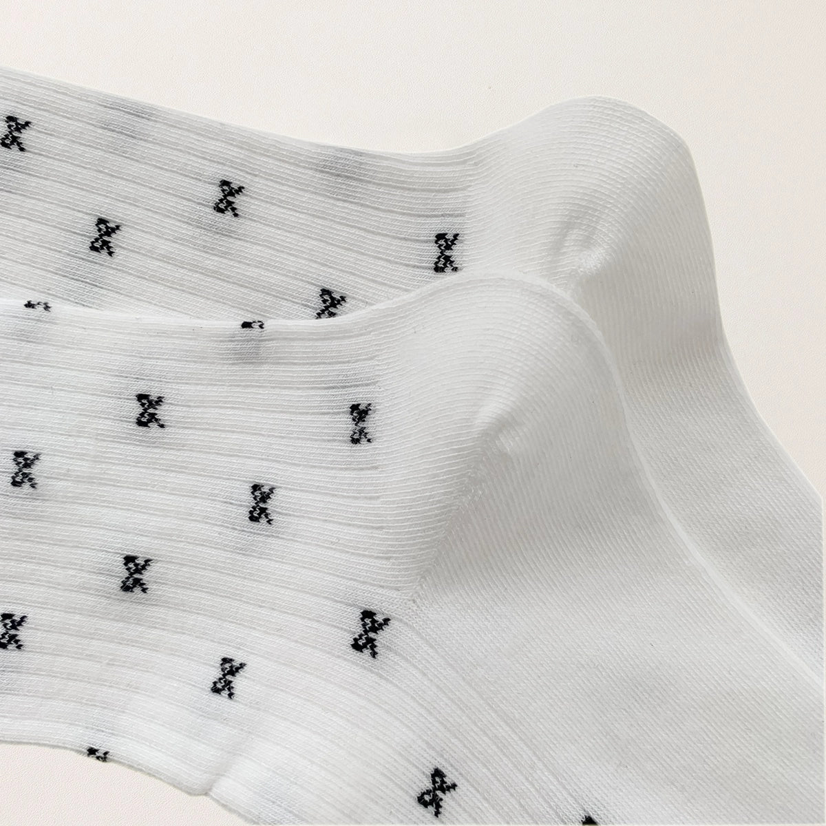 Chaussettes montantes tige côtelée. Motif petit noeud noir. Finition volant sur le haut de tige. Disponibles en blanc, gris chiné clair et noir. 