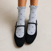 Chaussettes montantes tige côtelée. Motif petit noeud noir. Finition volant sur le haut de tige. Disponibles en blanc, gris chiné clair et noir. 