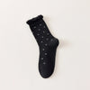 Chaussettes montantes tige côtelée. Motif petit noeud noir. Finition volant sur le haut de tige. Disponibles en blanc, gris chiné clair et noir. 