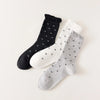 Chaussettes montantes tige côtelée. Motif petit noeud noir. Finition volant sur le haut de tige. Disponibles en blanc, gris chiné clair et noir. 