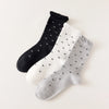 Chaussettes montantes tige côtelée. Motif petit noeud noir. Finition volant sur le haut de tige. Disponibles en blanc, gris chiné clair et noir. 