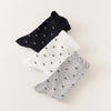 Chaussettes montantes tige côtelée. Motif petit noeud noir. Finition volant sur le haut de tige. Disponibles en blanc, gris chiné clair et noir. 