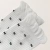 Chaussettes montantes tige côtelée. Motif petit noeud noir. Finition volant sur le haut de tige. Disponibles en blanc, gris chiné clair et noir. 