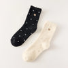 Chaussettes chaudes et douces, effet polaire, motif petits pois, tête d'ours brodée, proposée en noir et blanc cassé.