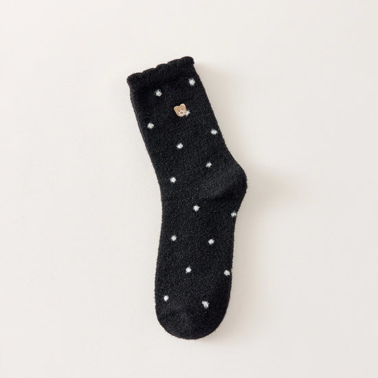 Chaussettes chaudes et douces, effet polaire, motif petits pois, tête d'ours brodée, proposée en noir et blanc cassé.