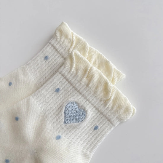 Chaussettes Volant Cœur & Pois femme vendues à l’unité. Modèles blanc à pois bleus ou gris bleu avec volant et cœur brodé. Taille unique 35-41.
