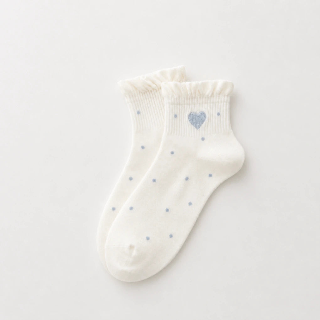 Chaussettes Volant Cœur & Pois femme vendues à l’unité. Modèles blanc à pois bleus ou gris bleu avec volant et cœur brodé. Taille unique 35-41.