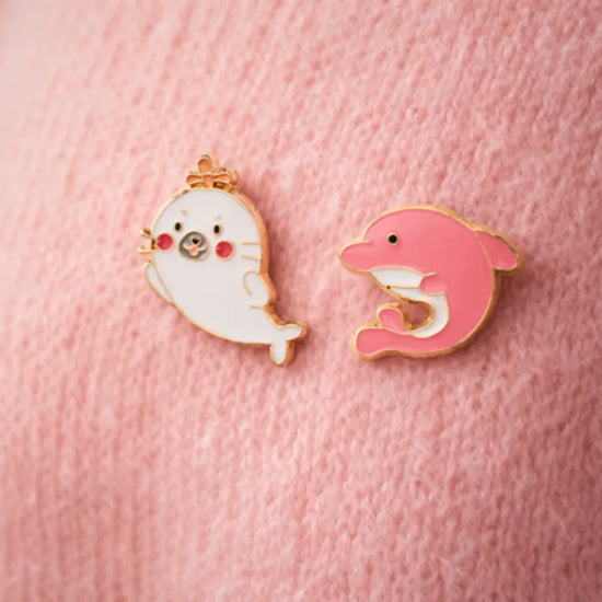 Lot de 2 pin's phoque blanc et dauphin rose.