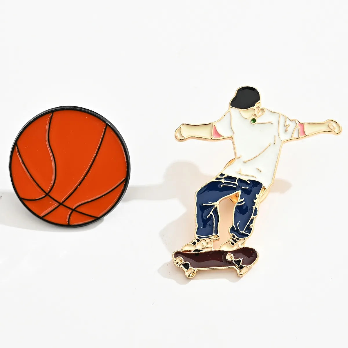 Lot de 2 pin's ballon de basket et skateur. 