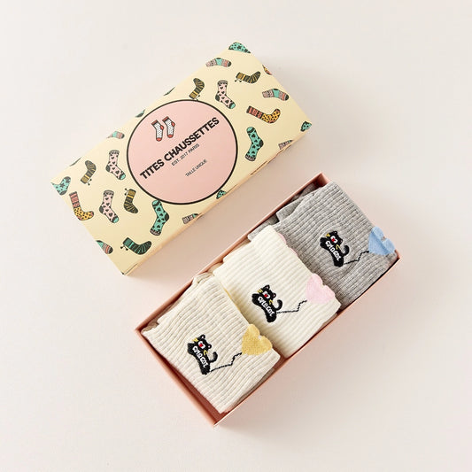 Lot de 3 chaussettes mi-hautes. Motif chat noir tenant un ballon en forme de coeur. Coloris blanc, beige et gris. Coeur contrasté.