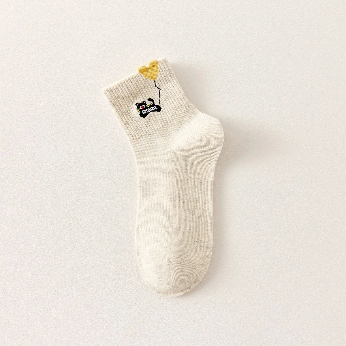 Lot de 3 chaussettes mi-hautes. Motif chat noir tenant un ballon en forme de coeur. Coloris blanc, beige et gris. Coeur contrasté.