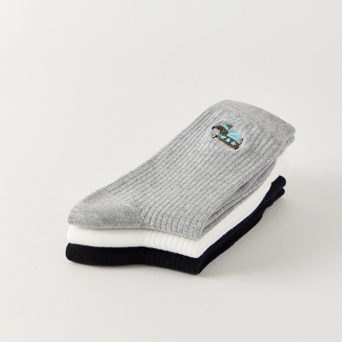 Lot de 3 chaussettes hautes côtelées. Coloris noir, gris chiné, blanc. Broderie petit chien sur l'extérieur du pied. 