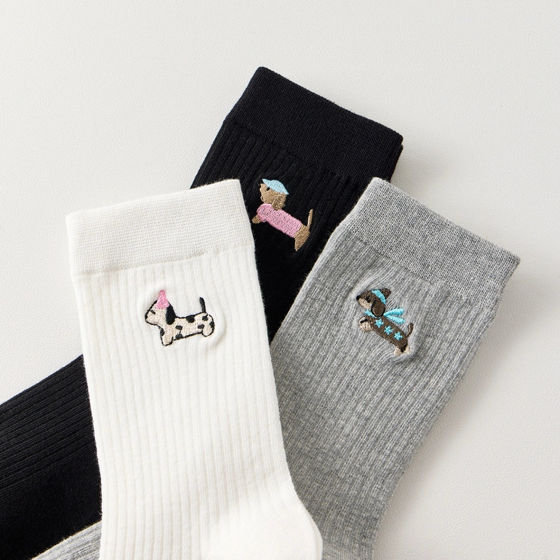 Lot de 3 chaussettes hautes côtelées. Coloris noir, gris chiné, blanc. Broderie petit chien sur l'extérieur du pied. 