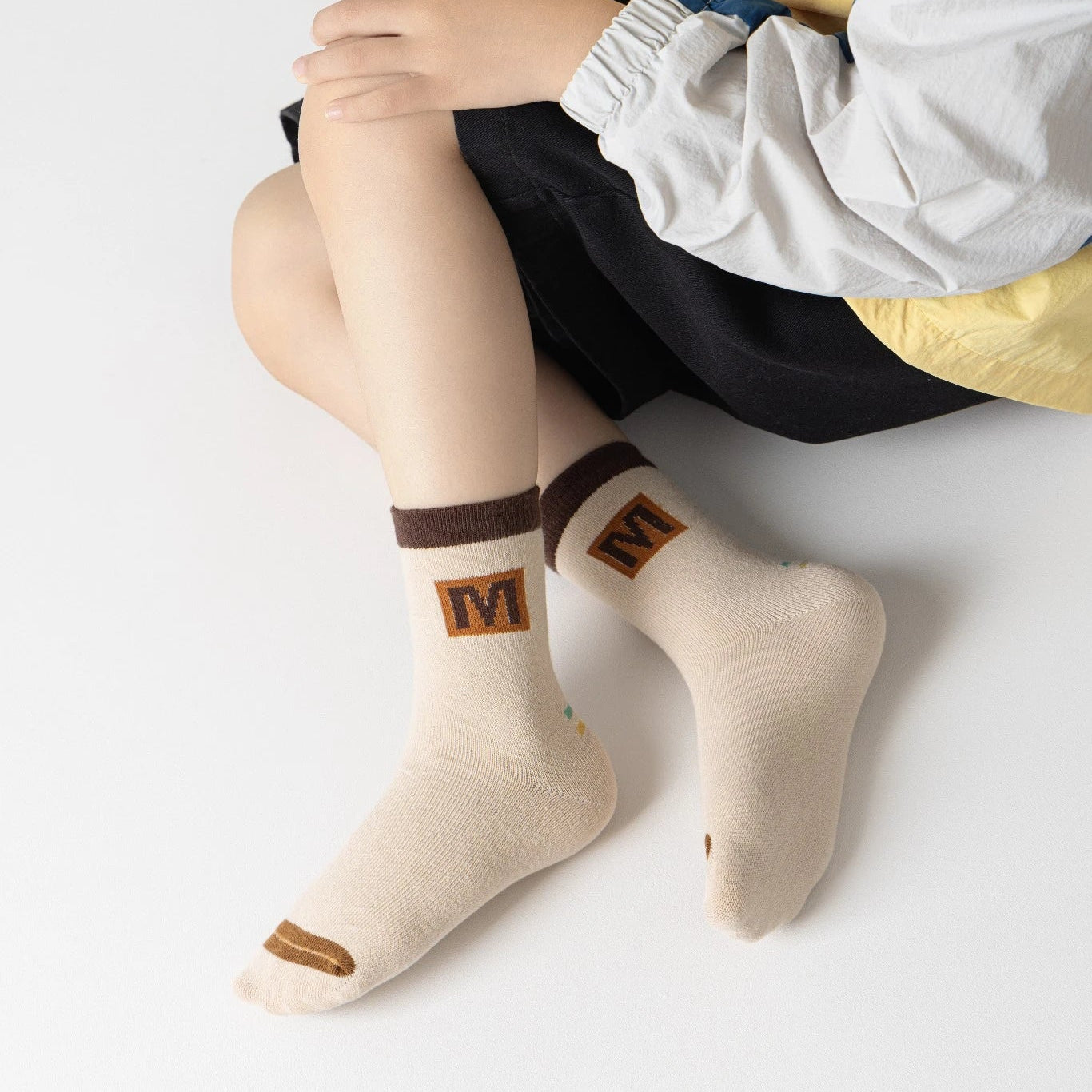 Lot de 5 chaussettes pour enfant (garçon).  Coloris beige / marron clair / marron foncé. Graphisme inspirés de l’univers citadin : inscription taxi, rayures, pois, numéro. 