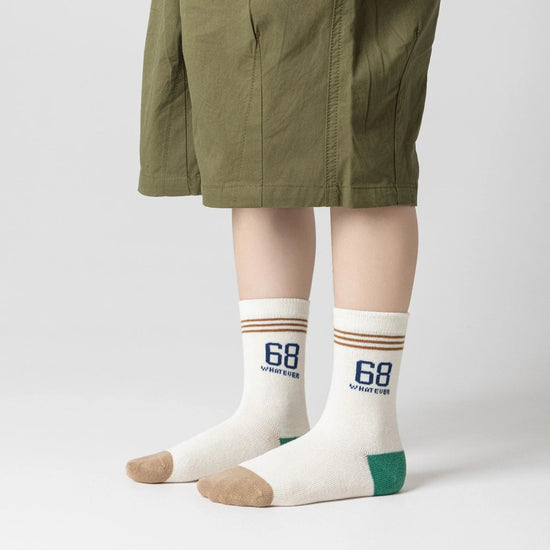 Lot de 5 chaussettes pour enfant (garçon).  Coloris beige / marron clair / marron foncé. Graphisme inspirés de l’univers citadin : inscription taxi, rayures, pois, numéro. 