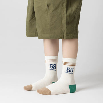 Lot de 5 chaussettes pour enfant (garçon).  Coloris beige / marron clair / marron foncé. Graphisme inspirés de l’univers citadin : inscription taxi, rayures, pois, numéro. 