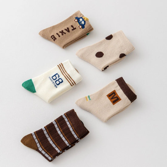 Lot de 5 chaussettes pour enfant (garçon).  Coloris beige / marron clair / marron foncé. Graphisme inspirés de l’univers citadin : inscription taxi, rayures, pois, numéro. 