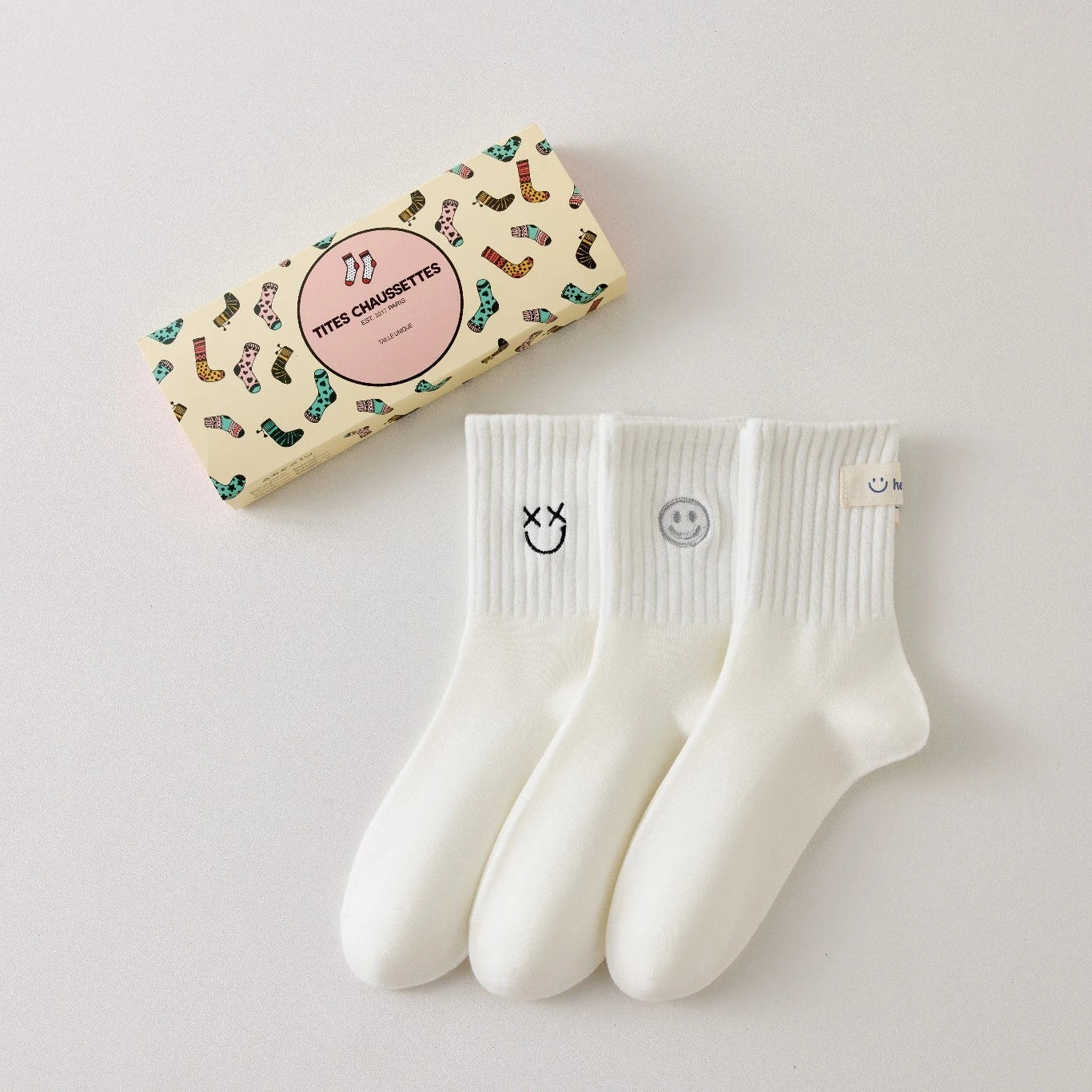 Lot de 3 chaussettes blanches montantes avec smiley, confortables et stylées, idéales avec des baskets. Coton épais, look tendance et maintien optimal.