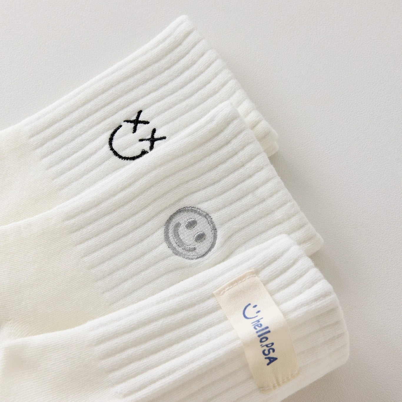 Lot de 3 chaussettes blanches montantes avec smiley, confortables et stylées, idéales avec des baskets. Coton épais, look tendance et maintien optimal.